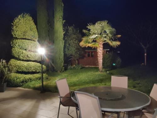 - une table et des chaises dans la cour la nuit dans l'établissement Évasion, à Ambillou