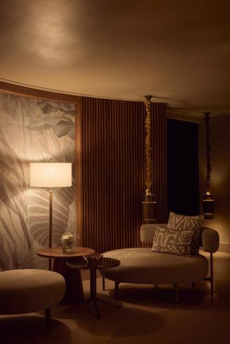 a living room with a bed and a table and a lamp at Nobu Hotel Marrakech in Marrakech