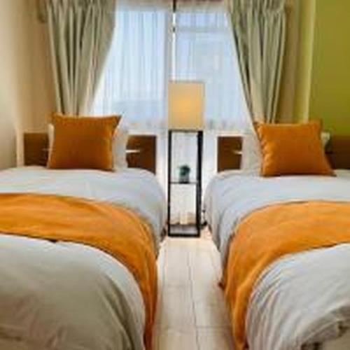 a bedroom with two beds and a window at First Tennoji East 602 ファースト天王寺東 602 in Osaka