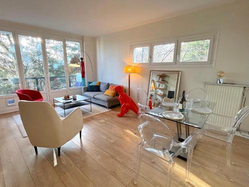 un salon avec un canapé, une table et des chaises dans l'établissement L'appartement Dantan, à Saint-Cloud