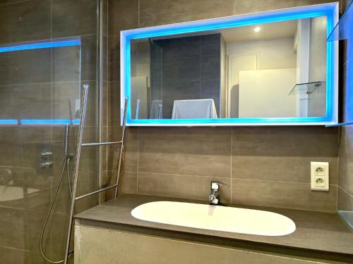 une salle de bain avec un lavabo et un miroir dans l'établissement L'appartement Dantan, à Saint-Cloud