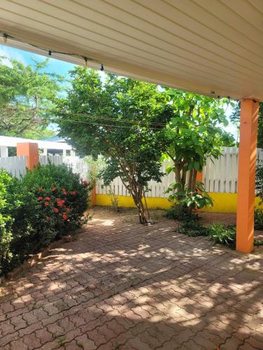 a patio with trees and a yellow fence at Cozy studio feat private garden in Noord
