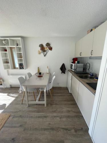 une cuisine et une salle à manger avec une table et des chaises dans l'établissement Location Studio Cabine St Lary Soulan, à Saint-Lary-Soulan