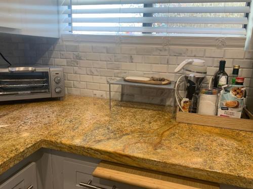 a kitchen counter with a sink and a microwave at Sunny Retro Row Condo- Walk to Beach! in Long Beach