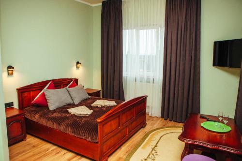 a bedroom with a bed and a table and a television at Європа готель in Solomonovo