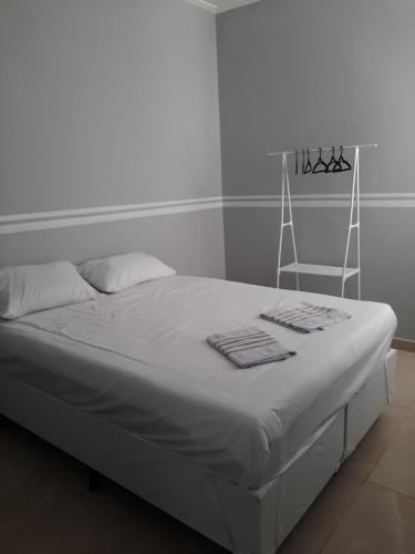 a white bed with towels on it in a room at Casa Linda PÉ Na areia , Cabo Frio in Cabo Frio