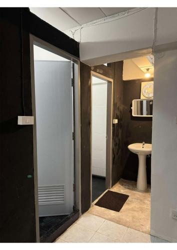 an open door to a bathroom with a sink at MaHar Hostel ChiangMai in Chiang Mai