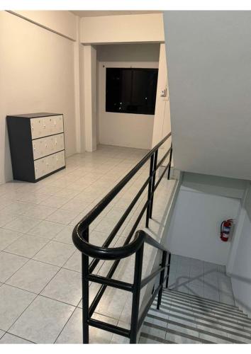 a staircase in a room with a dresser and a television at MaHar Hostel ChiangMai in Chiang Mai