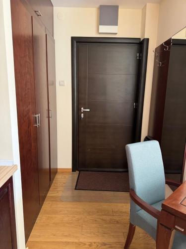 a door in a room with a chair and a table at Mecava Lux Kopaonik in Kopaonik