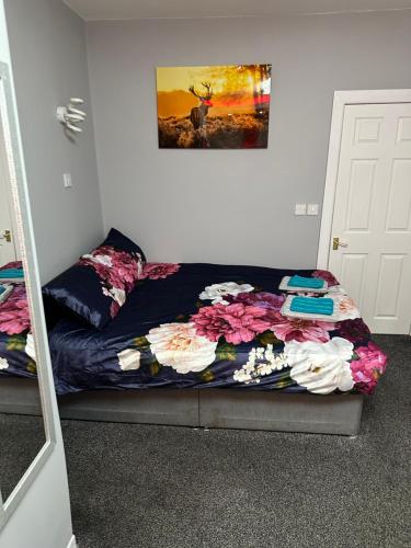 a bedroom with a bed with a floweridered blanket at Blackpool Beach Holiday Flats in Blackpool