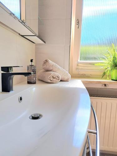 a white sink in a bathroom with a window at Ferienhaus zum Eibsee in Grainau