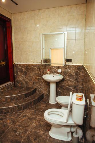 a bathroom with a toilet and a sink and a mirror at Європа готель in Solomonovo
