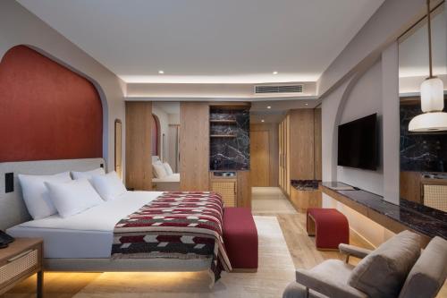 a hotel room with a bed and a tv at Liberty Signa in Fethiye