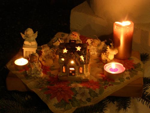 a table topped with a gingerbread house and candles at Őrségi Tornácos Vendégfogadó in Felsőszenterzsébet