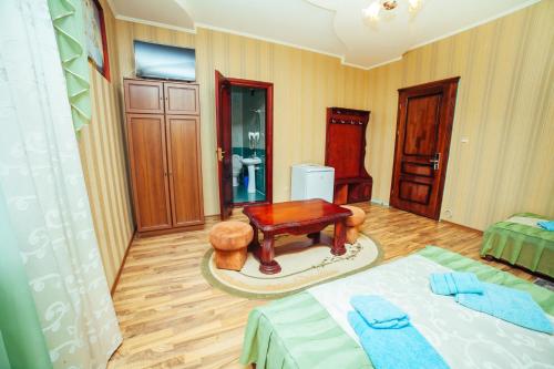 a room with a bed and a table and a stool at Європа готель in Solomonovo