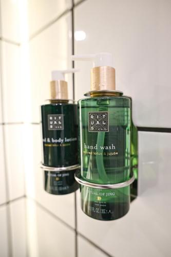 two green bottles on a wall in a bathroom at Black Gallo Residences in Belgrade