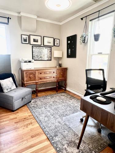 a living room with a desk and a chair at Eco-Friendly Sunnyside 3 Bedroom Bungalow in Denver