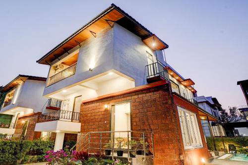 a large brick building with a balcony on it at ELIVAAS 3 BHK Aamy Villa with Pvt Pool & Garden in Lonavala