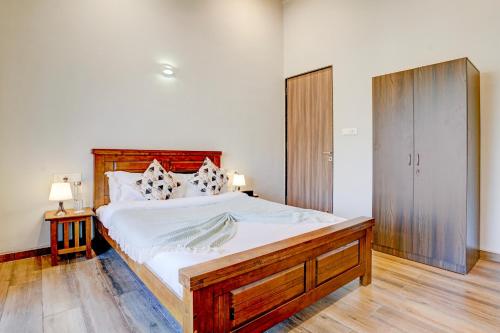 a bedroom with a large bed with a wooden headboard at ELIVAAS 3 BHK Aamy Villa with Pvt Pool & Garden in Lonavala