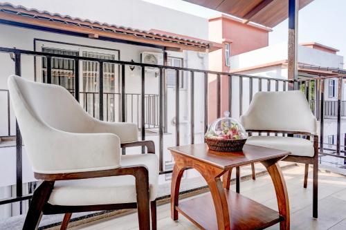 two chairs and a table on a balcony at ELIVAAS 3 BHK Aamy Villa with Pvt Pool & Garden in Lonavala