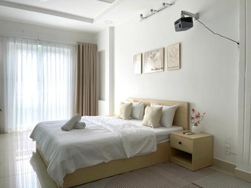 a bedroom with a large bed with white sheets and pillows at Ann Home in Ho Chi Minh City