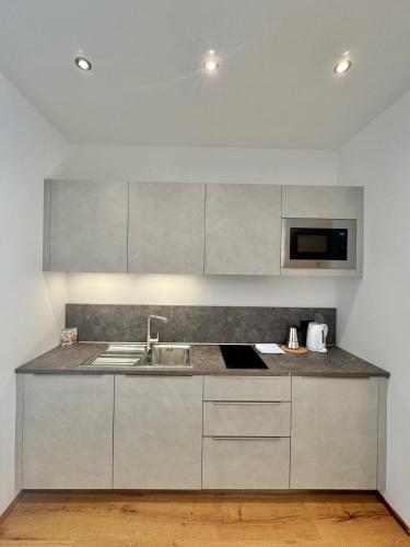 a kitchen with a sink and a microwave at Residence Vajolet San Cassiano in San Cassiano