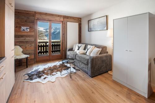 a living room with a couch and a table at Studio rénové avec vue sur les montagnes in Vex