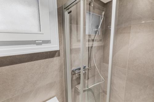 a shower with a glass door in a bathroom at Studio rénové avec vue sur les montagnes in Vex