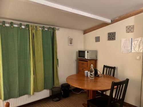 Cette petite chambre comprend une table et un four micro-ondes. dans l'établissement A room and garden close to Paris, à Vitry-sur-Seine