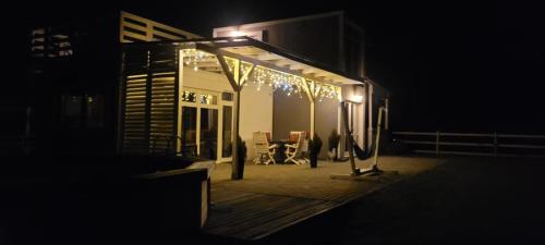 a house with lights on a deck at night at Domek na Pagórku in Lwówek Śląski
