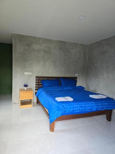 a bedroom with a blue bed and a night stand at Ao Nang Khao Kaeo Resort in Ao Nang Beach