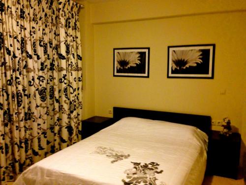 een slaapkamer met een bed en twee foto's aan de muur bij REM Apartments in Thessaloniki
