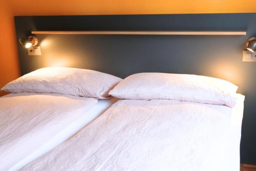 two white pillows sitting on top of a bed at Eiger Lodge Easy in Grindelwald