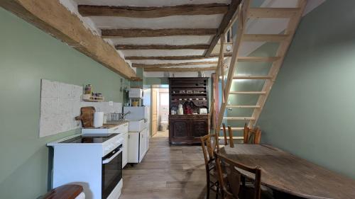 une cuisine avec une table en bois et une échelle dans l'établissement Le Cottage et la Tiny des Cartes - 2 maisons, à LʼÎle Bouchard