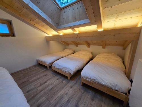 two beds in a room with a roof at Le chalet des belges - Saint-Gervais in Saint-Gervais-les-Bains