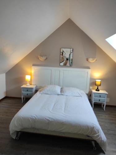 une chambre avec un grand lit blanc avec deux tables dans l'établissement Maison Pivert, à Saint-Denis-sur-Sarthon