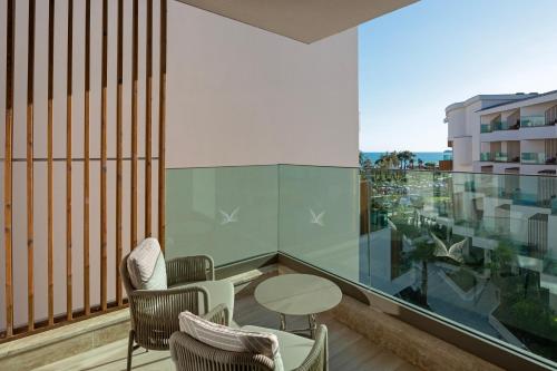a balcony with chairs and a table and a window at Liberty Signa in Fethiye