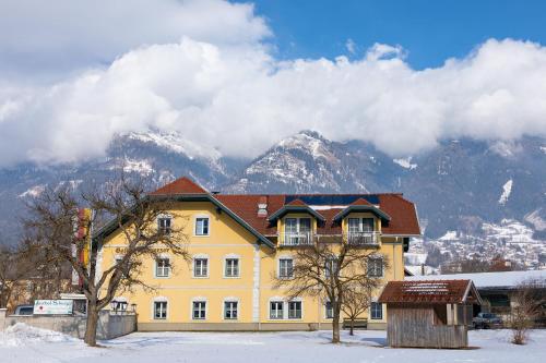 a yellow building with snowy mountains in the background at Haus Altenmarkt in Möllbrücke