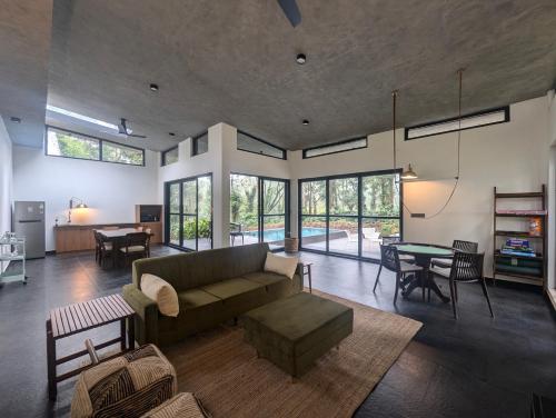 un soggiorno con un divano e un tavolo di Earthsong & Birdsong Luxury Pool Villa by Luxunlock Private Villas a Suntikoppa