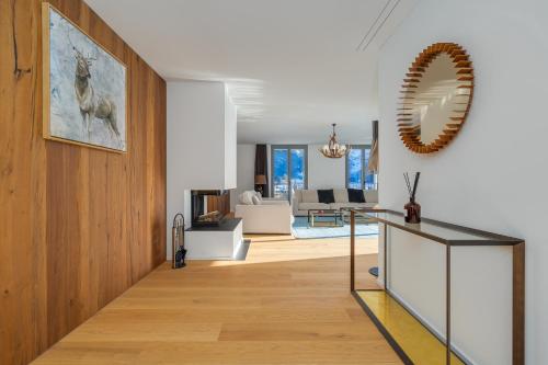 a living room with a table and a mirror at Swiss Hotel Apartments - Engelberg in Engelberg