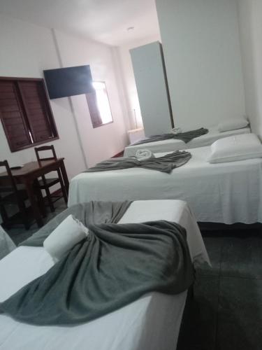 two beds in a hotel room with a mirror at Pousada Girassol in Maceió