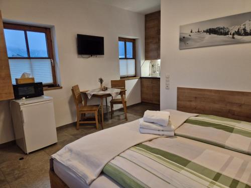 a bedroom with a bed and a table and a television at Riedhof-Zuahaus in Breitenbach am Inn