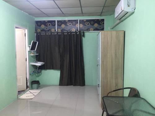Una habitación con una cortina y una mesa y una puerta. en Walking Street Pattaya Beach Ordinary Rooms Guest House วอล์คกิ้งสตรีทพัทยาชายหาดพัทยาห้องธรรมดาเกสท์เฮ้าส์, en Pattaya central