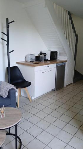 une cuisine avec un comptoir et un escalier dans l'établissement Maison avec jardin- à 3' du lac, à Hourtin