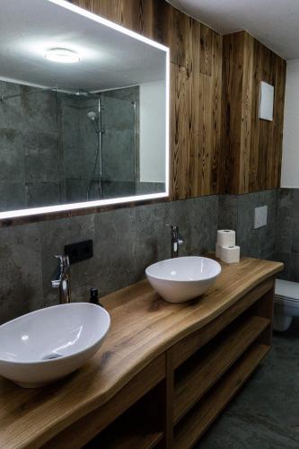 two sinks on a wooden counter in a bathroom at SÖLLHOF Ferienhaus mit 11 Schlafzimmern I großer Gemeinschaftsraum I Skibushaltestelle I 10 Min zum Skigebiet in Krimml