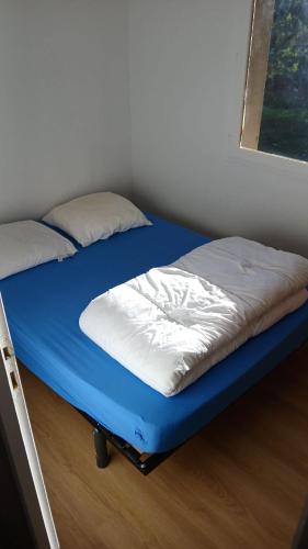 Ce lit se trouve dans un dortoir doté d'un matelas bleu. dans l'établissement Maison avec jardin- à 3' du lac, à Hourtin