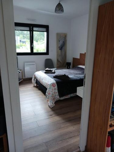 a bedroom with a bed and a wooden floor at chambre d'hôte proche mer in Yvias