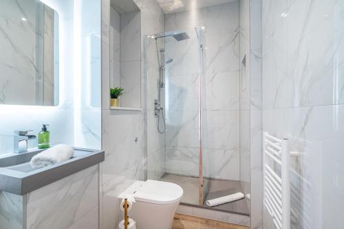 a white bathroom with a shower and a toilet at Penthouse Collection by EPIC in Liverpool