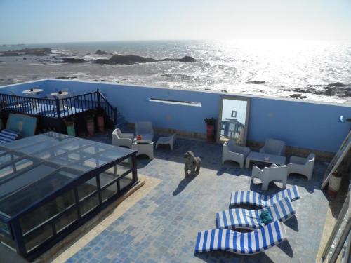 a patio with chairs and a table and the ocean at La Maison des Artistes in Essaouira