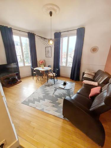 un salon avec un canapé et une table dans l'établissement La suite 21, 73 m2 de charme, Centre ville, à Dijon